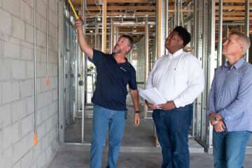 A picture of a GL Homes construction developer showing a home to prospective clients