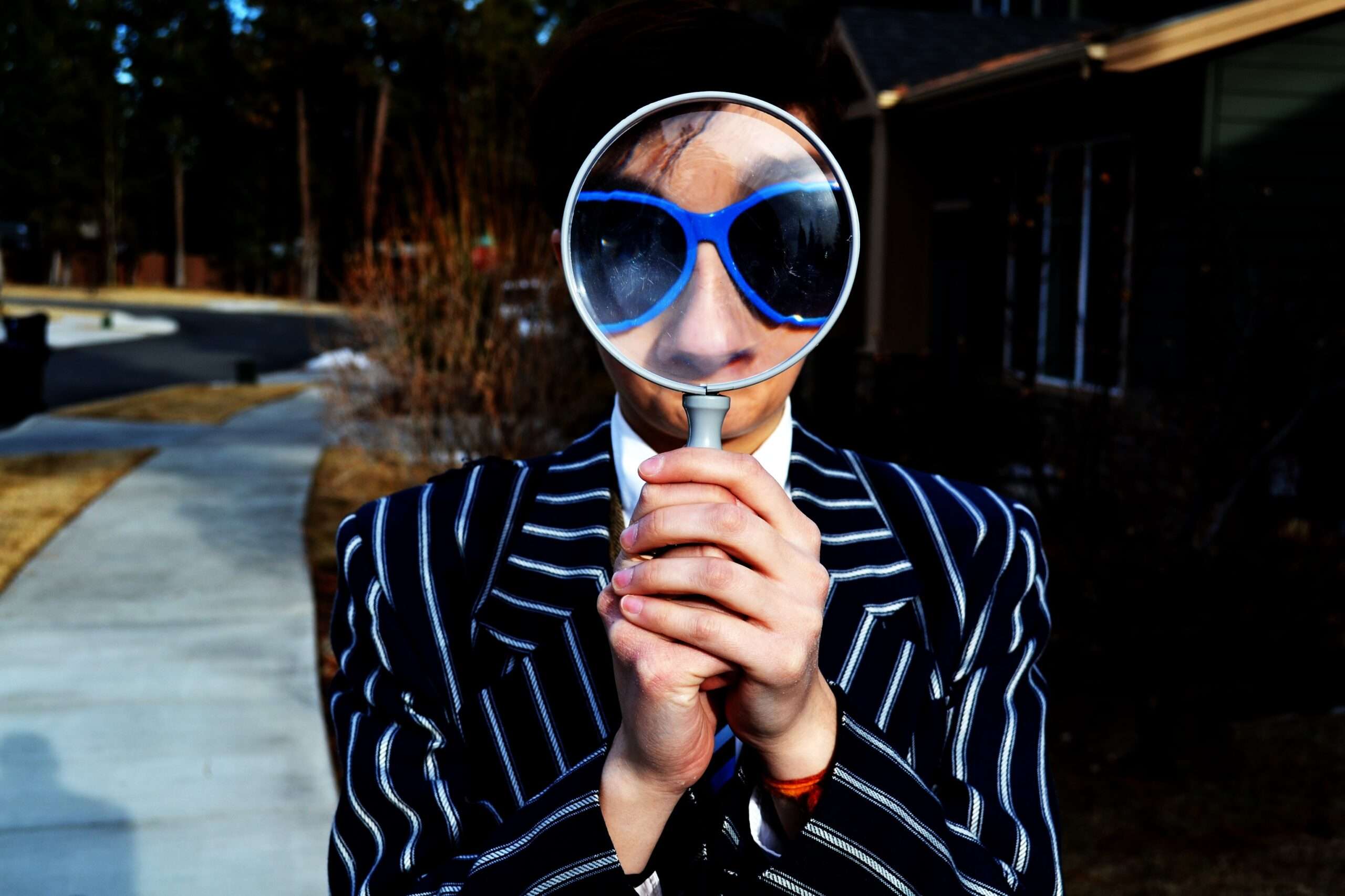 A person holding a magnifying glass.