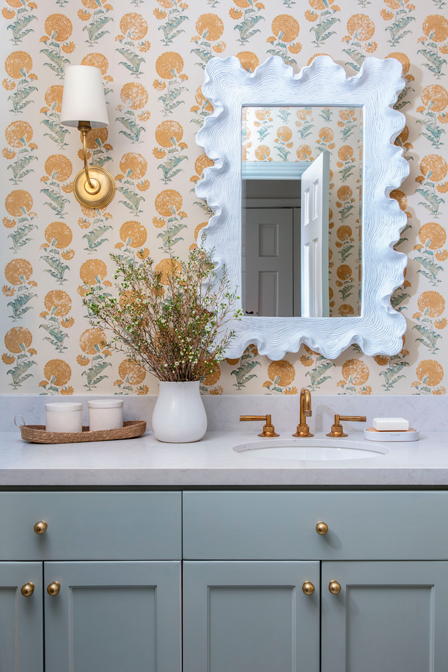 wallpapered bathroom with blue vanity